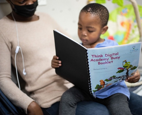 A patient reading the Think Digital Academy Busy Booklet in hospital.